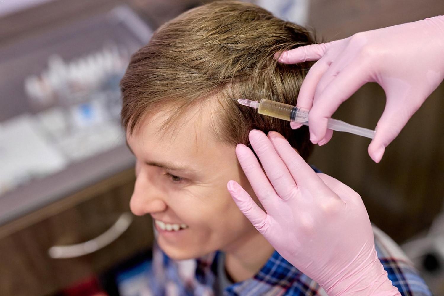 Male patient receiving PRP scalp mesotherapy at an aesthetic clinic